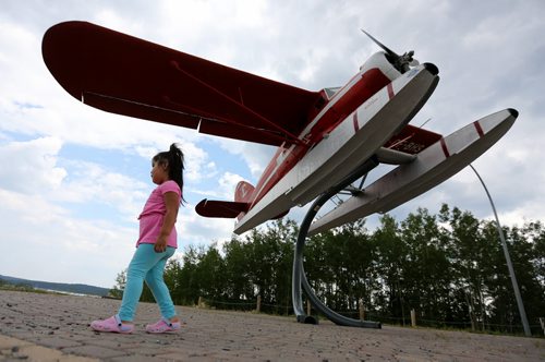 Zoey Munroe, 2, from Oxford House, playing under the Lamb Airways float plane near the Miles Hart Bridge, in Thompson, Monday, July 22, 2013. (TREVOR HAGAN/WINNIPEG FREE PRESS)