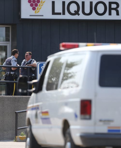 RCMP officers outside the Liquor Commission in Thompson as customers arrive immediately after it opens at 11am, Monday, July 22, 2013. (TREVOR HAGAN/WINNIPEG FREE PRESS)