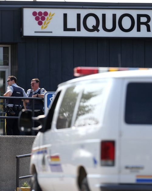 RCMP officers outside the Liquor Commission in Thompson as customers arrive immediately after it opens at 11am, Monday, July 22, 2013. (TREVOR HAGAN/WINNIPEG FREE PRESS)