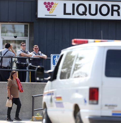 RCMP officers outside the Liquor Commission in Thompson as customers arrive immediately after it opens at 11am, Monday, July 22, 2013. (TREVOR HAGAN/WINNIPEG FREE PRESS)