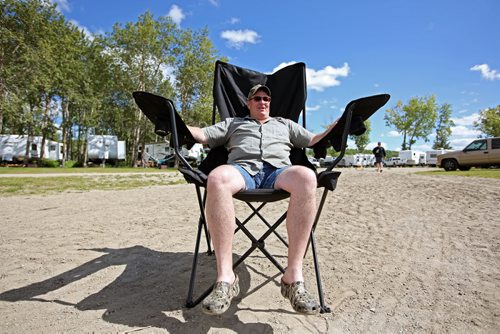 Brandon Sun 27072013 Brock McIntosh of Carberry relaxes at the beach in an oversized lounge chair  on Saturday while camping with friends at the Minnedosa Beach Campground. (Tim Smith/Brandon Sun)