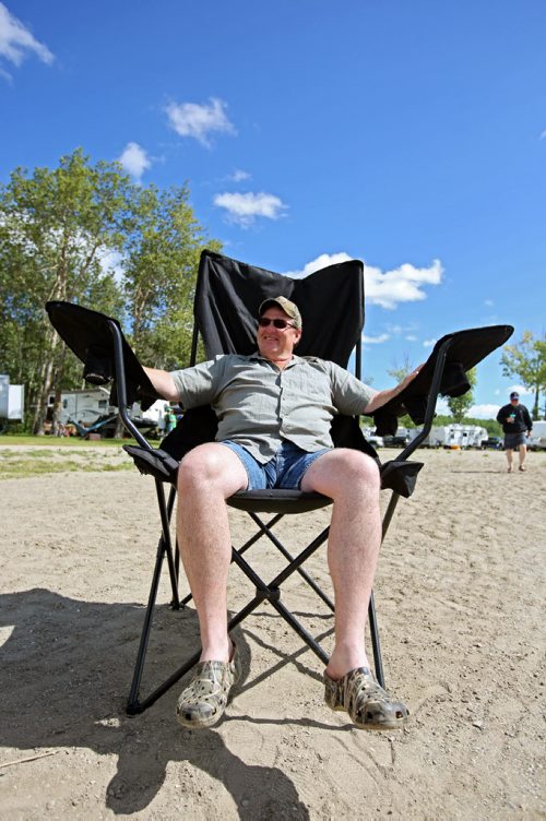 Brandon Sun 27072013 Brock McIntosh of Carberry relaxes at the beach in an oversized lounge chair  on Saturday while camping with friends at the Minnedosa Beach Campground. (Tim Smith/Brandon Sun)