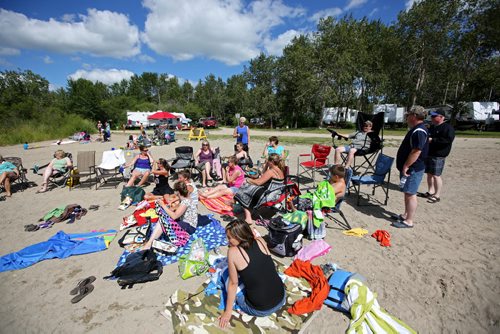 Brandon Sun 27072013 A large group of friejnds from Carberry relax at the beach on Saturday while camping at the Minnedosa Beach Campground. (Tim Smith/Brandon Sun)