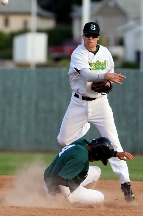 Brandon Sun 28072013 Garrett Popplestone #10 of the Brandon Cloverleafs throws the ball to first after tagging Ryan Cooper #4 of the Neepawa Farmers out at second base during MSBL semifinal playoff action at Andrews Field on Sunday evening. (Tim Smith/Brandon Sun)