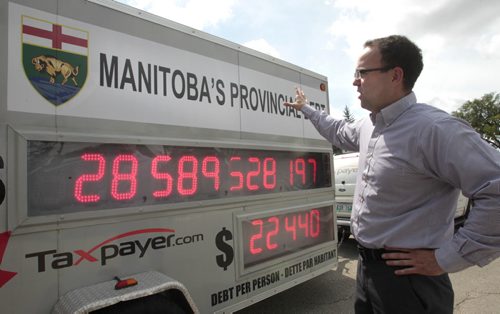 Colin Craig, Prairie Director with the Canadian Taxpayers Federation parked their Debt Clock in front of the Manitoba Legislative Building Tuesday, the score board showing Manitoba's debt increasing by more than $72 per second or approximately $6.25 million per day.   Larry Kusch story Wayne Glowacki / Winnipeg Free Press July 30 2013