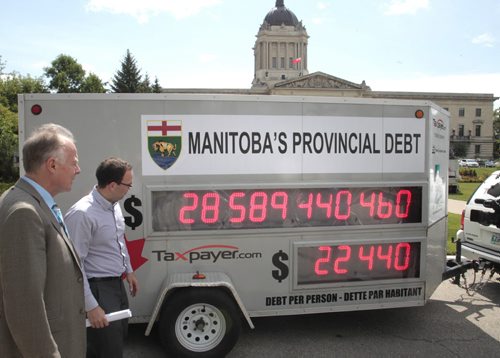 At Left, Manitoba Liberal Leader Jon Gerrard chats with Colin Craig, Prairie Director with the Canadian Taxpayers Federation after Colin parked their CTF Debt Clock in front of the Manitoba Legislative Building Tuesday, the score board showing Manitoba's debt increasing by more than $72 per second or approximately $6.25 million per day.   Larry Kusch story Wayne Glowacki / Winnipeg Free Press July 30 2013