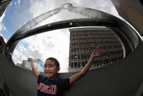 Noah Sevilla, 9, enjoys the mist as it flows out of the sculpture titled "emptyful," by Bill Pechet, outside of the Millennium Library Tuesday afternoon. 130730 - July 30, 2013 Mike Deal / Winnipeg Free Press