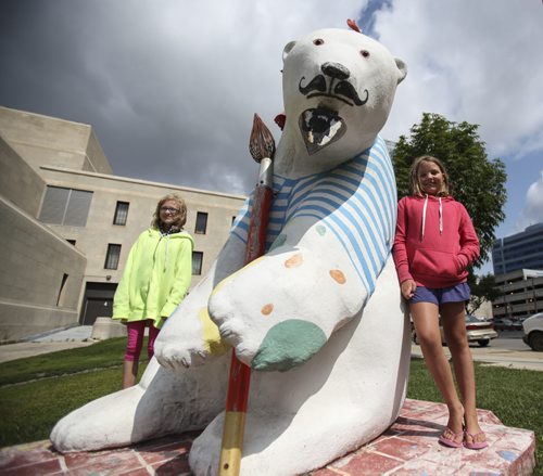 CancerCare bears on the move. Sisters Cassidee Crackle (right), 10, and Elizabeth, 12, pose for one last photo -- the last photo -- with the artist bear located at York and Vaughn St. Both sculptures at that location as well as several located behind the Manitoba Legislature along Assiniboine Dr. were removed today and transported to a new home. Wednesday, July 31, 2013. (JESSICA BURTNICK/WINNIPEG FREE PRESS)