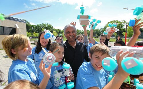 Lord Selkirk Summer Learning program students surround Strini Reddy (centre) founder, as they show off their  homemade rockets after press conference by Education Minister Nancy Allen announcing the expansion of the CSI  Program.  See Carol Sanders story. August 1, 2013 Ruth Bonneville Winnipeg Free Press