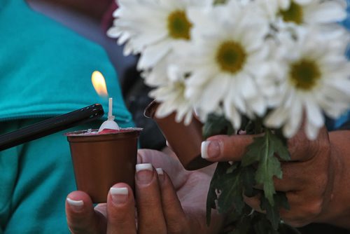 Mourners light a candle during the vigil in memory of Gibson and her two children, two-year-old Anna and three-month-old Nicholas at The Forks Thursday evening. 130801 - August 01, 2013 Mike Deal / Winnipeg Free Press