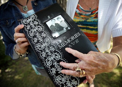 adine Konyk and her mother Jocelyne hold and look through her father's "memorial scrapbook".  Story about family of deceased former Winnipeg firefighter who accidentally lost his memorial scrapbook and moms grief journal (it fell out of the trunk of their car when they were gathering for the anniversary of his death in 2012. He died of  cancer in 2011) about 15 months ago. The other day, a little old lady walked into a fire station at McGregor and Redwood and dropped both items off in a bag. Nobody got her name and they dont know how she came by the album and journal. Fire Station captain, Brent Cheater, recognized the firefighter (Dave Konyk) and managed to track down family. Mother Jocelyne now lives in Quebec, but just happened to be in town helping daughter Nadine move to Alberta this week. August 2, 2013 - (Phil Hossack / Winnipeg Free Press)