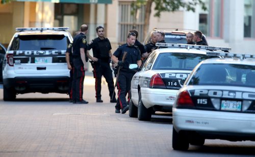 An officer carries a rifle to the back of a police car following a standoff at The Albert, Friday, August 2, 2013. (TREVOR HAGAN/WINNIPEG FREE PRESS)