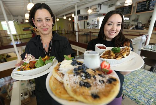 Talia Syrie, Food Service Coordinator holding the Wild Rice Croquette, Pancakes with Blueberries and Jade McIvor holding the Poutine, at Come 'n Eat inside Neechi Commons, Friday, August 2, 2013. (TREVOR HAGAN/WINNIPEG FREE PRESS)