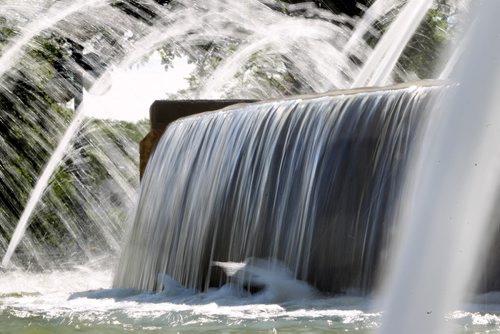 The sun illuminates the cascading water as it makes its way over the edges of the fountain  behind the  Legislature Saturday. Standup photo. August  03,, 2013 Ruth Bonneville Winnipeg Free Press