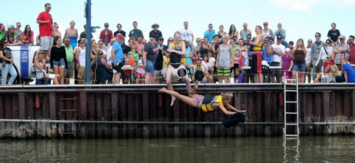 Competitors battle one another with a sponge filled sack, while sitting on a soap covered beam over Gimli Harbour during the Islendingadunk competition at the Icelandic Festival of Manitoba in Gimli, Saturday, August 3, 2013. (TREVOR HAGAN/WINNIPEG FREE PRESS)