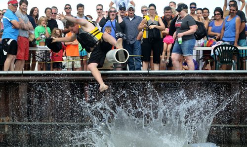 Competitors battle one another with a sponge filled sack, while sitting on a soap covered beam over Gimli Harbour during the Islendingadunk competition at the Icelandic Festival of Manitoba in Gimli, Saturday, August 3, 2013. (TREVOR HAGAN/WINNIPEG FREE PRESS)