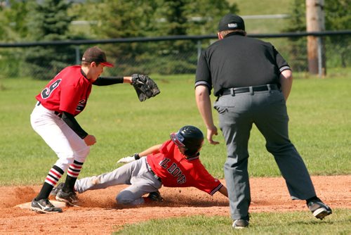 Brandon Sun 08042013 Dawson Sobry #33 of Oildome slides safely into second base before the ball makes it to Nathan Slaby #19 of the North Winnipeg Pirates during their Peewee AAA Provincial Championship semifinal match at Simplot Millennium Park on Monday. (Tim Smith/Brandon Sun)
