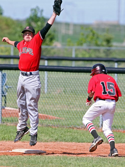 Brandon Sun 08042013 First baseman Grady Hobbs #8 of Oildome leaps to for a catch asCole Olfert #15 of the North Winnipeg Pirates runs to the bag during their Peewee AAA Provincial Championship semifinal match at Simplot Millennium Park on Monday. (Tim Smith/Brandon Sun)