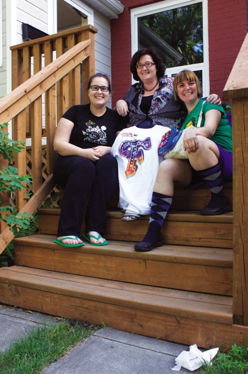 Canstar Community News July 24, 2013 - Winnipeg Fringe Festival performers Brie Watson (left) and Erin Rodgers (right) of Toronto flank billet host Heather Madill in front of Madill's Elmwood home. The Toronto duo put on the sketch comedy production Water Wings during the festival. (DAN FALLOON/CANSTAR COMMUNITY NEWS/HERALD)