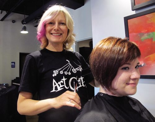 Canstar Community News July 25, 2013- Mary-Lynne Kenneth (left) gives Melissa Hollinf a quick trim at Looks Hair and Body on Corydon Avenue. Kenneth has organized ArtCity Wednesdays. Every first Wednesday of the month she will be giving $25 basic haircuts with all proceeds going to ArtCity. (STEPHCROSIER/CANSTAR)