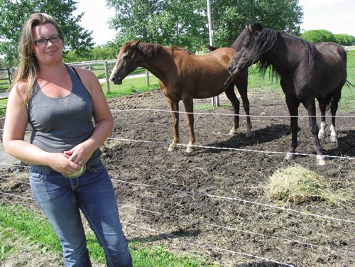Canstar Community News July 30, 2013 - Owner of Dacotah Performance Horses Sarah Southwell stands next to two of the horses at her boarding and riding stable in Dacotah. (ANDREA GEARY/CANSTAR COMMUNITY NEWS)