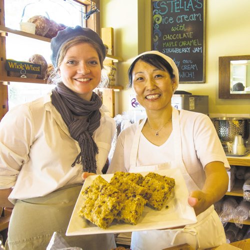 Canstar Community News Aug. 7 -- Kate Edmond, Bakery Manager, and Zhimin Yang, Baker, of Stella's Bakery on Sherbrook Street offer up a plate of Wolseley bars.  Gail Perry/SPECIAL TO CANSTAR