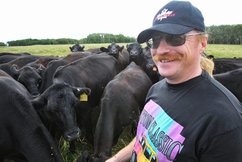 James Kebernik amongst some of his cattle that will eventually end up as burgers in the restaurant he runs with his wife at Robyn's Drive In on Hwy 12 and 317. 130807 - August 07, 2013 Mike Deal / Winnipeg Free Press