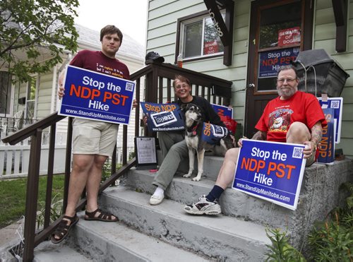 Lauri St. Germain (centre) has been handing out "Stop the NDP PST Hike" signs around her neighbourhood and the city of Winnipeg. She began by picking them up from the Progressive Conservative office in order to make the signs available from her home on Burrows Ave. outside regular business hours, but she's no longer alone. Neighbour Jim Jim Pico (left) and Christian Sweryda (right) heard what she was doing and now help deliver the signs to others. Wednesday, August 7, 2013. (ADAM WAZNY) (JESSICA BURTNICK/WINNIPEG FREE PRESS)