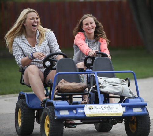 Cousins Cassie Jackson (left) and Courtney Maines take a buggy for a spin around The Forks Market on Friday afternoon. Friday, August 9, 2013. (JESSICA BURTNICK/WINNIPEG FREE PRESS)