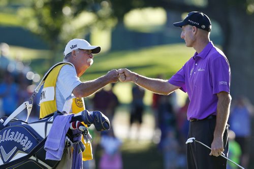 Jim Furyk (R) of the U.S. fist-bumps his caddie, Mike Cowan, on the 18th green during the third round of the 2013 PGA Championship golf tournament at Oak Hill Country Club in Rochester, New York August 10, 2013. REUTERS/Jeff Haynes (UNITED STATES  - Tags: SPORT GOLF)   - RTX12GNO