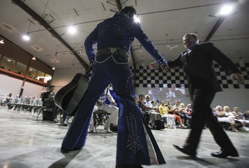Gerry "Big Bear" Barrett of Winnipeg (left) is greeted to the stage by emcee Quinn Greene. His hobby and passion turned into his business, as he's been putting on his blue jumpsuit for the past three years. Gimli Elvis Festival on Saturday, August 10, 2013. He is one of (JESSICA BURTNICK/WINNIPEG FREE PRESS)