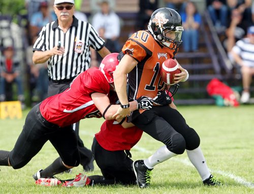 Brandon Sun 10082013 Quarterback Seth Hume #10 of the Westman Wolverines is dragged down by St. Vital Mustangs players during Manitoba Major Football League action at Vincent Massey High School on Saturday afternoon. (Tim Smith/Brandon Sun)