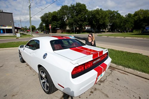 Brandon Sun 10082013 Angela Blue dries off her husbands Dodge Challenger after washing it at the car wash on Park Ave. on a sunny Saturday morning. (Tim Smith/Brandon Sun)