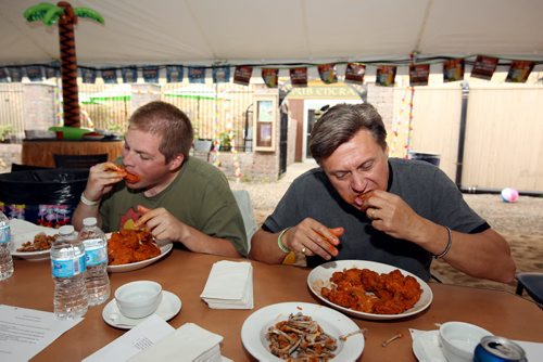 Brandon Sun 10082013 Danny Wilson and Frank McGuire work their way through as many hot wings as they can in seven minutes during the wing eating competition at the 1st Annual Margarita-Ville Beach Party at The Dock on Princess on Saturday afternoon. (Tim Smith/Brandon Sun)