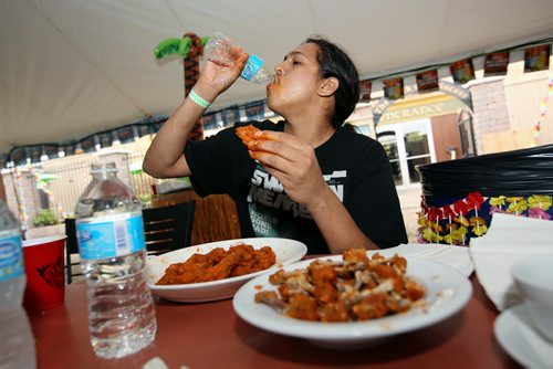 Brandon Sun 10082013 Josh Duff works his way through as many hot wings as he can in seven minutes during the wing eating competition at the 1st Annual Margarita-Ville Beach Party at The Dock on Princess on Saturday afternoon. (Tim Smith/Brandon Sun)