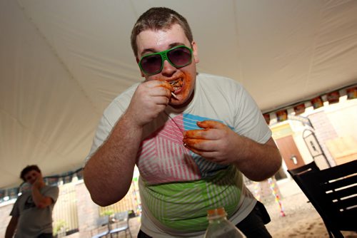 Brandon Sun 10082013 Lane Quigley works his way through as many hot wings as he can in seven minutes during the wing eating competition at the 1st Annual Margarita-Ville Beach Party at The Dock on Princess on Saturday afternoon. (Tim Smith/Brandon Sun)