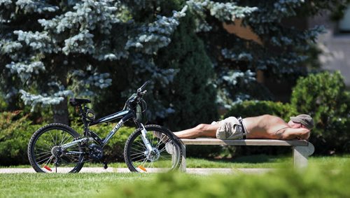 A cyclist takes a break, listens to some tunes and catches some sun in Memorial Park Sunday. 130811 - August 11, 2013 Mike Deal / Winnipeg Free Press