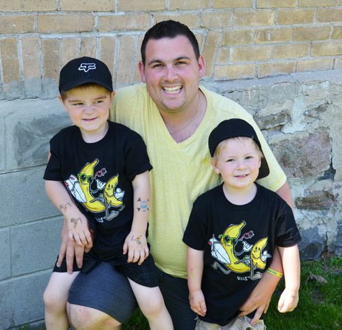 Brandon Sun Banana Days president Camiel Serruys hangs out with his son  Quinton and nephew Damian after a hot dog in Melita Sunday afternoon. (Lauren Parsons/Brandon Sun)