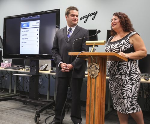 Citizens of Winnipeg can now connect with the city's 311 service using their mobile phones, thanks to the Winnipeg 311 App launched today. The announcement was made at the 311 Contact Centre at City Place by Councillor Jeff Browaty (left) and contact centre manager Melanie Swenarchuk. Tuesday, August 13, 2013. (ELIZABETH FRASER) (JESSICA BURTNICK/WINNIPEG FREE PRESS)