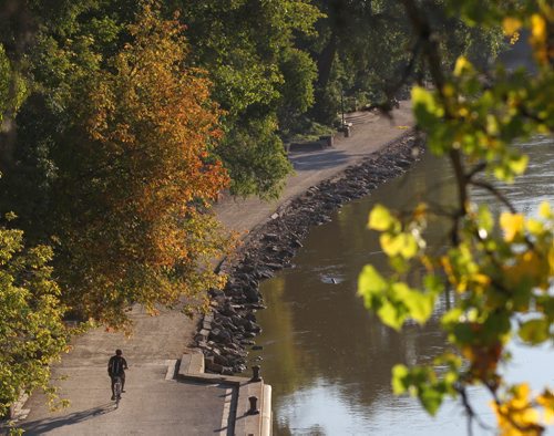 Morning light cascades over trees as a cyclist maneuvers the river walk on the Assiniboine River as seen from the Donald St bridge- Highs in Winnipeg are predicted to be 25C  -Standup Photo- August 14, 2013   (JOE BRYKSA / WINNIPEG FREE PRESS)