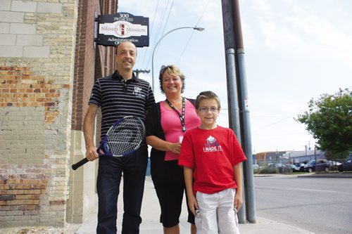 Canstar Community News Aug. 6, 2013 - Harbour View South resident Markus Deutsch (left) is planning an eight-hour tennis marathon in support of Siloam Mission on Sept. 7. Also pictured are Siloam director of resource development Judy Richichi and Deutsch's eight-year-old son Josiah. (DAN FALLOON/CANSTAR COMMUNITY NEWS/HERALD)