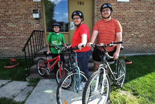 Shelley Sauve and her two kids Miguel, 10, and Gary, 17, with their bikes. It's a cheap activity they use in the summer months to save money. 130814 - August 14, 2013 Mike Deal / Winnipeg Free Press