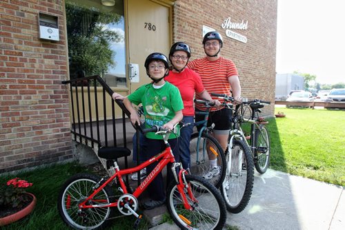 Shelley Sauve and her two kids Miguel, 10, and Gary, 17, with their bikes. It's a cheap activity they use in the summer months to save money. 130814 - August 14, 2013 Mike Deal / Winnipeg Free Press