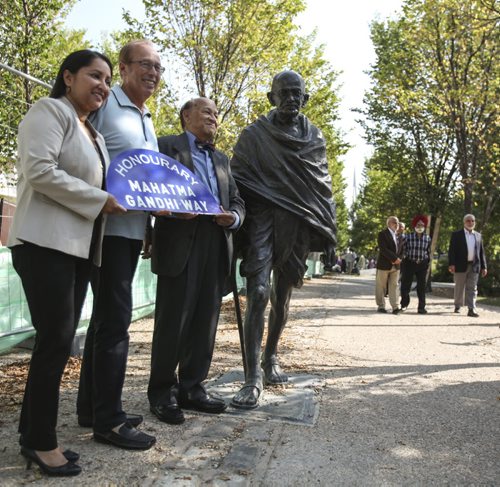 (Left to right) Councillor Devi Sharma, Mayor Sam Katz and Dr. K. Dakshinamurti (president of the Mahatma Gandhi Centre of Canada) stand with an effigy of Mahatma Gandhi on the newly renamed Mahatma Gandhi Way today (formerly the Broadway Promenade). It is located between the skatepark and Canadian Museum of Human Rights. Thursday, August 15, 2013. (JESSICA BURTNICK/WINNIPEG FREE PRESS)