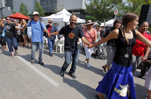 LOCAL - Abo dance - LETS DANCE - Noonish, on the side of the new MB Hydro building between Graham and Portage, streets were closed as the public was invited to join aboriginals in attempt to set a record for Worlds Largest Friendship Dance. It's the start of Manito Ahbee Festival. BORIS MINKEVICH / WINNIPEG FREE PRESS. August 15, 2013.