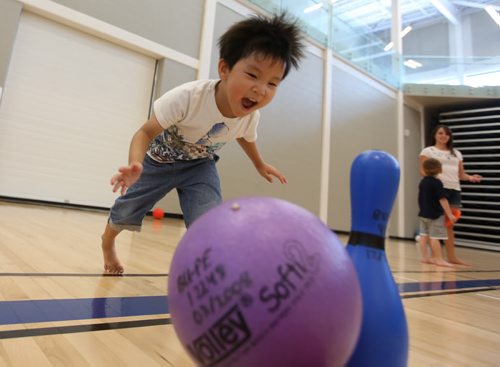Brandon Sun 16082013 Aiden practices his bowling skills while playing in the BU Healthy Living Centre with other children from the BU Early Leaning Centre on Friday afternoon. (Tim Smith/Brandon Sun)