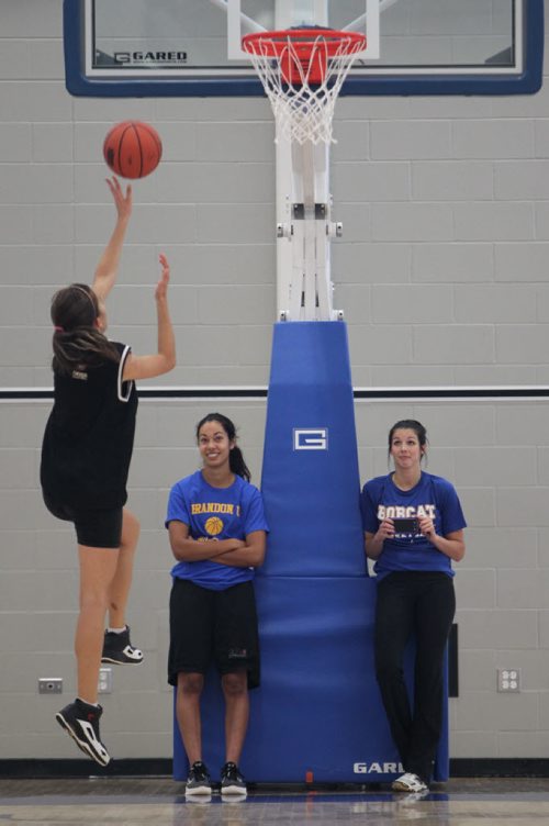 Brandon Sun 16082013 Brandon Bobcats women's basketball player Kaela Cranston and assistant coach Sarah Lopes watch as a participant takes a shot on net during the Girls Performance Camp at the BU Healthy Living Centre on Friday. (Tim Smith/Brandon Sun)