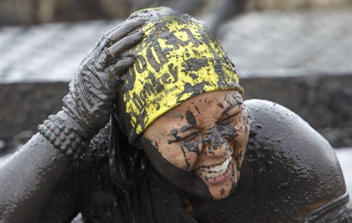 Lillian Mendoza emerges from a pit full of mud near the finish line of the Dirty Donkey Run at Springhill, Saturday, August 17, 2013. (TREVOR HAGAN/WINNIPEG FREE PRESS)