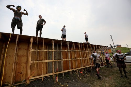 Participants on top of the Wall of Shame during the Dirty Donkey Run, a 5km run through a muddy obstacle course, at Springhill, Saturday, August 17, 2013. (TREVOR HAGAN/WINNIPEG FREE PRESS)