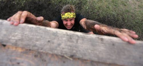 Mark Lawsome climbs the Wall of Shame during the Dirty Donkey Run, a 5km run through a muddy obstacle course, at Springhill, Saturday, August 17, 2013. (TREVOR HAGAN/WINNIPEG FREE PRESS)